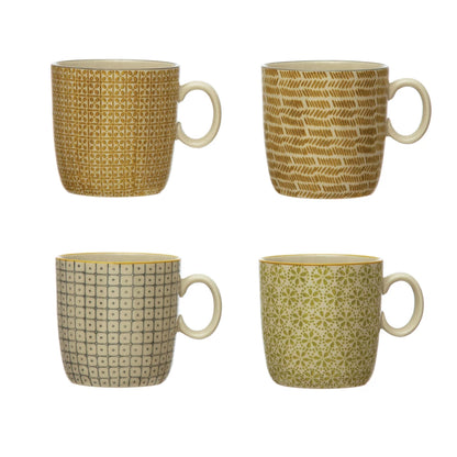 four different patterned stamped stoneware mugs on a white background