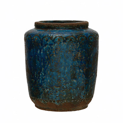 deep blue vase with  bits of exposed terracotta and a simple arched design along the top.
