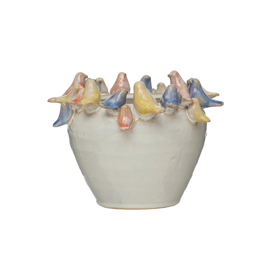 off-white planter with small yellow, pink, and blue birds arranged around the rim.