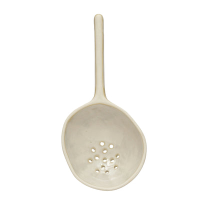 large stoneware strainer spoon on white background.