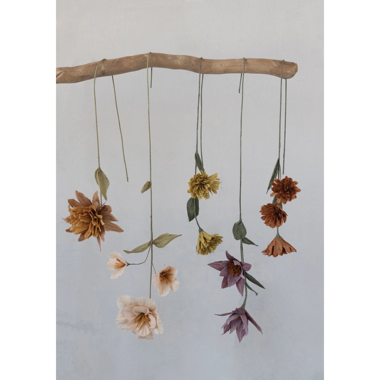 assorted paper flowers hanging upside down from a branch.