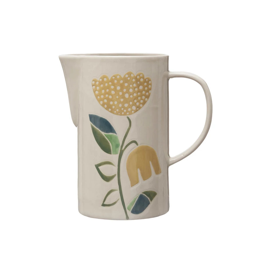 off-white ceramic pitcher with yellow flowers and a grenn stem and leaves.