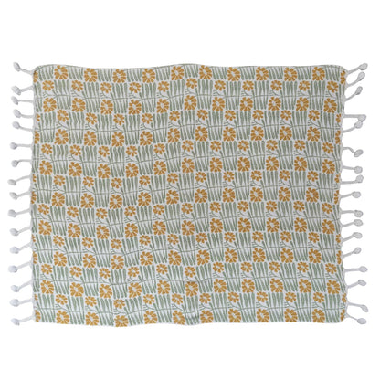 off-white blanket with yellow flower and green leaf pattern laying flat on a white background.
