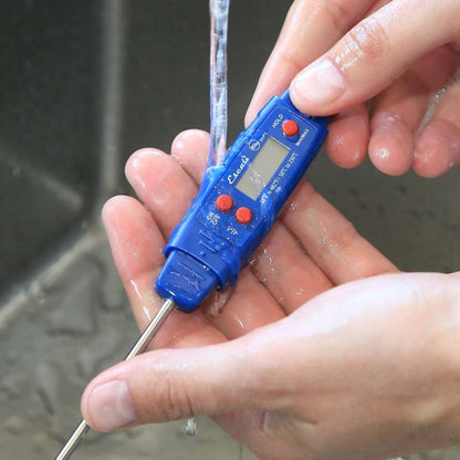 waterproof digital thermometer being held under running water in a sink
