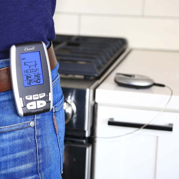 a person wearing the wireless remote thermometer and time while standing in a kitchen 