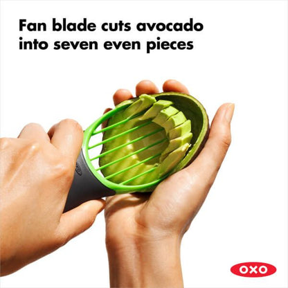 hands holding avocado and slicer removing flesh from avocado.