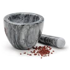 mortar with pestle and spices next to it.