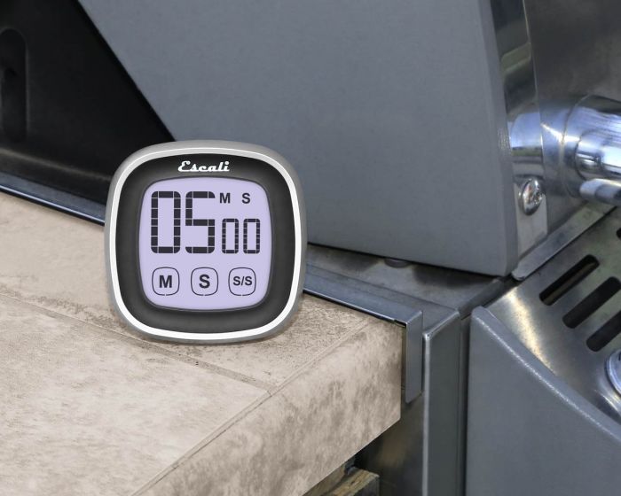 the touch screen digital time displayed on a countertop by a  grill