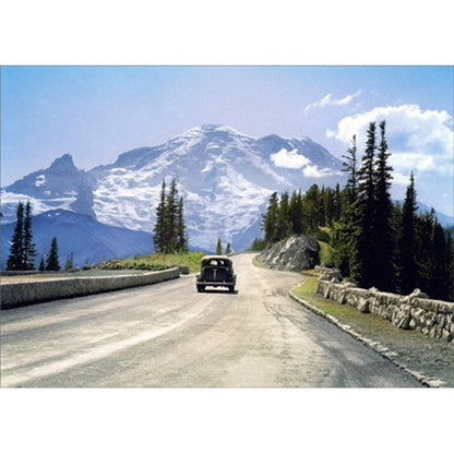 front of card is a photograph of a car from the 1950s driving towards a large mountain range