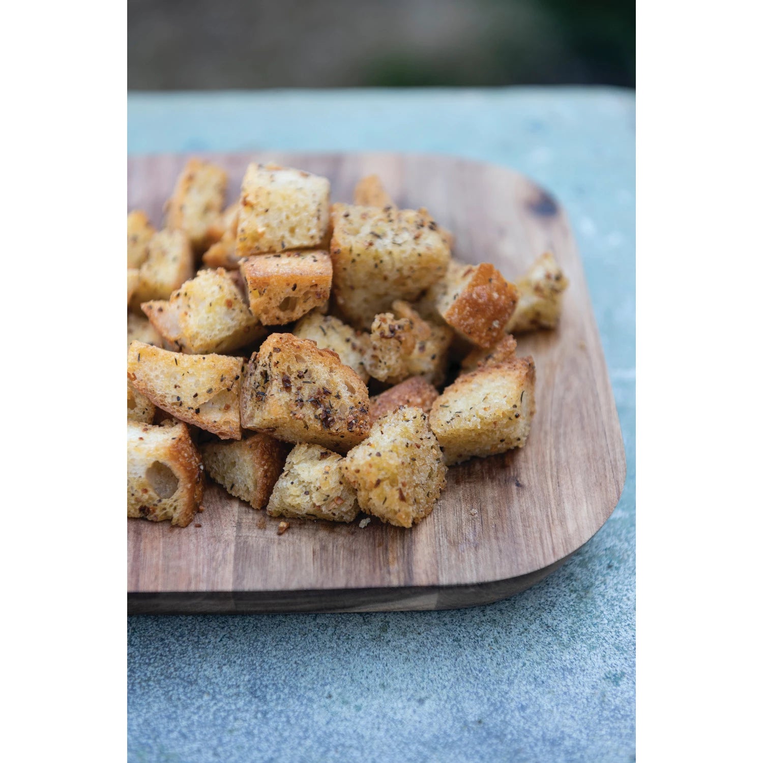 croutons seasoned in all purpose seasoning and displayed piled on a wooden board 