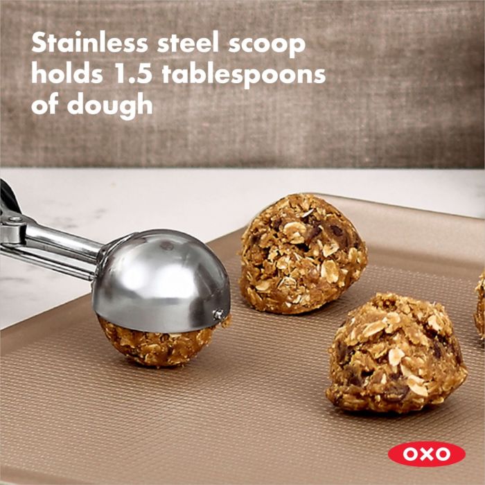 scoop putting balls of dough onto baking sheet.