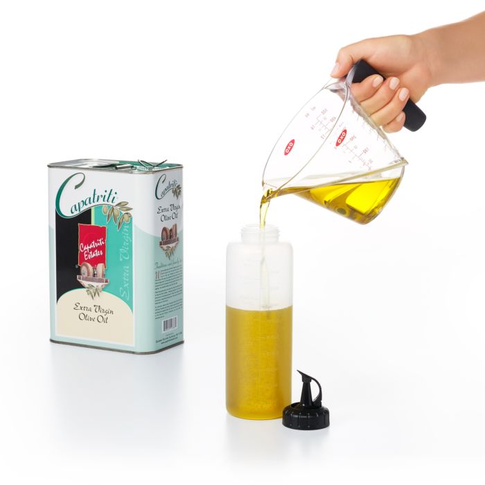 hand pouring olive oil into squeeze bottle.