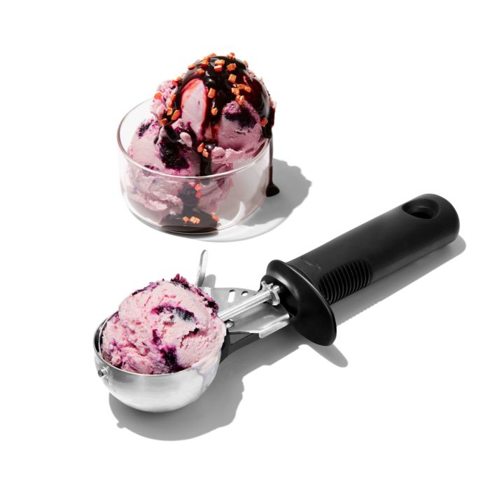 ice cream scoop filled with ice cream and bowl of ice cream with chocolate sauce.