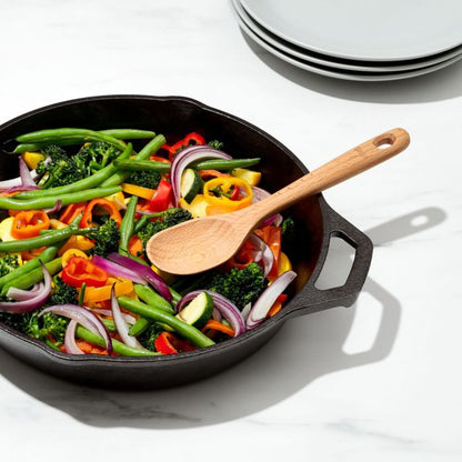 spoon laying on veggies in pan.