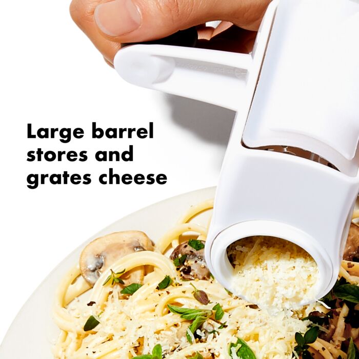 hand grating cheese onto plate of pasta with text "large barrel stores and grates cheese".