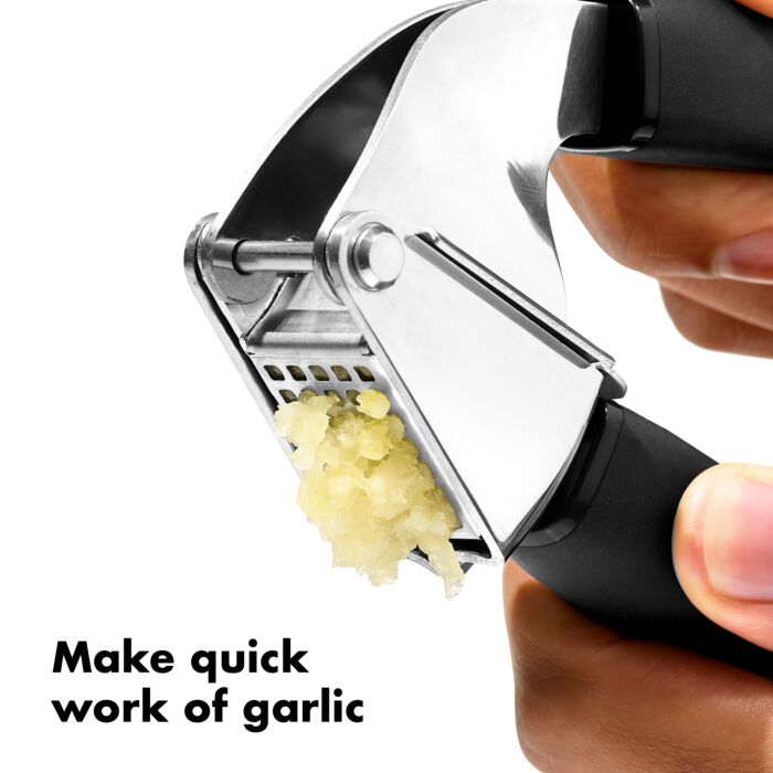 a persons hands illustrating how quickly you can press garlic against a white background
