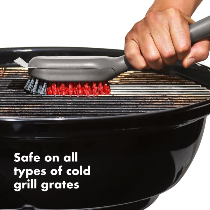 hand holding brush and cleaning grill with text "safe on all types of cold grill grates".