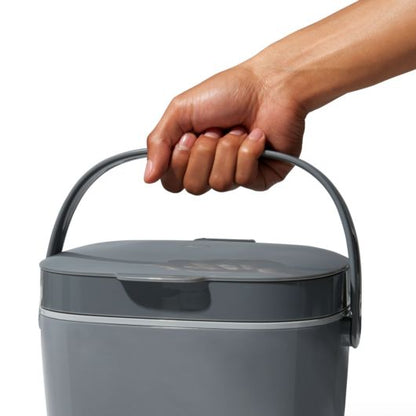 hand holding handle of compost bucket.