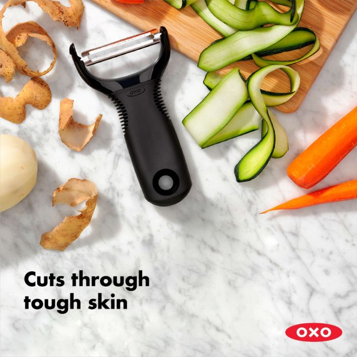 peeler on counter with peeled veggies and text "cuts through tough skin".