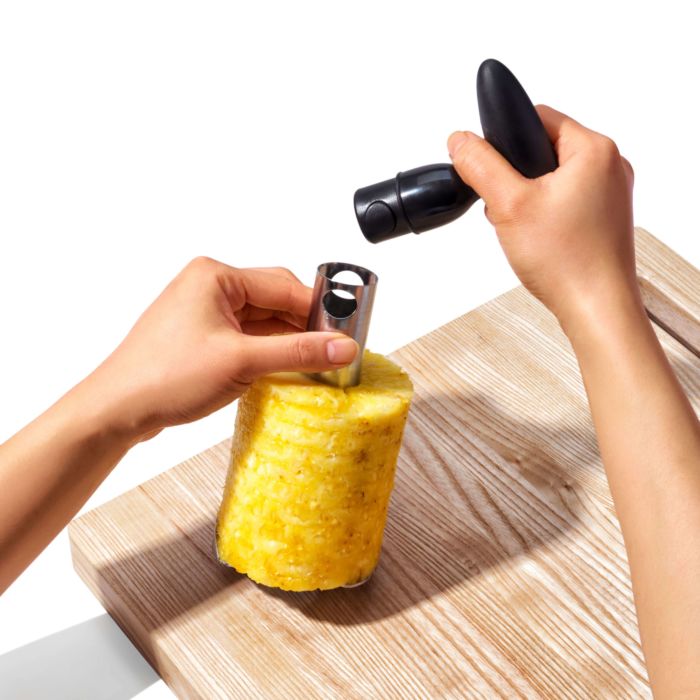 hand removing slicer handle from slicer with pineapple rings on it.