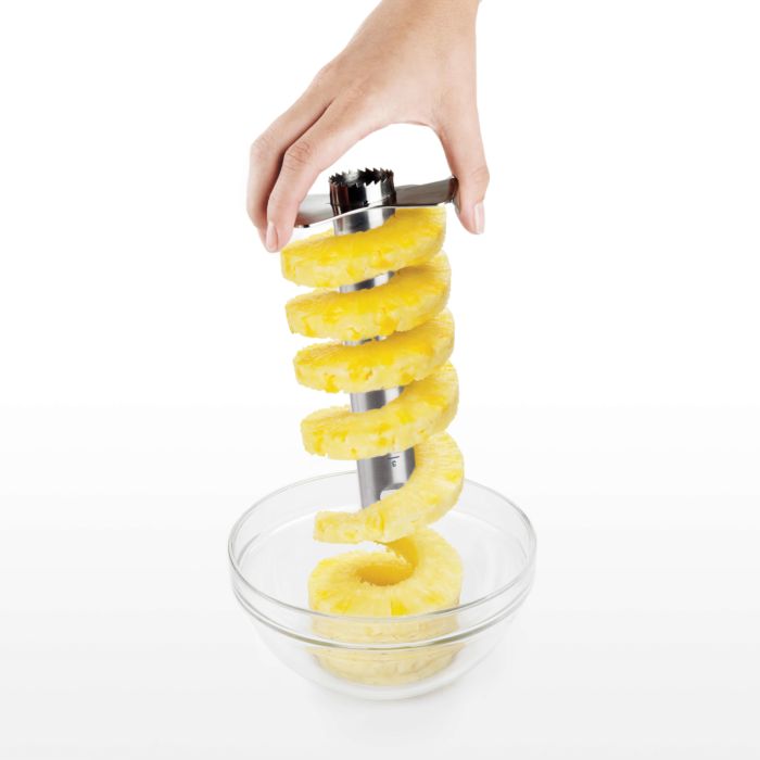 hand putting pineapple rings into bowl.