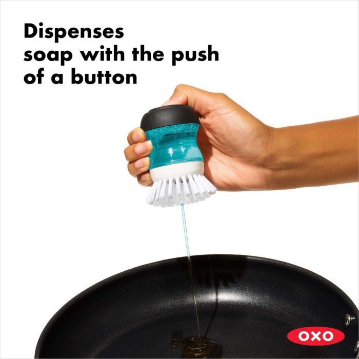 hand holding brush filled with soap and text "dispenses soap with the push of a button".