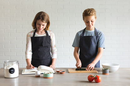 2 kids wearing apron while baking.