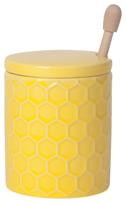 yellow ceramic pot with honey comb pattern on it with a lid and wooden honey dipper.