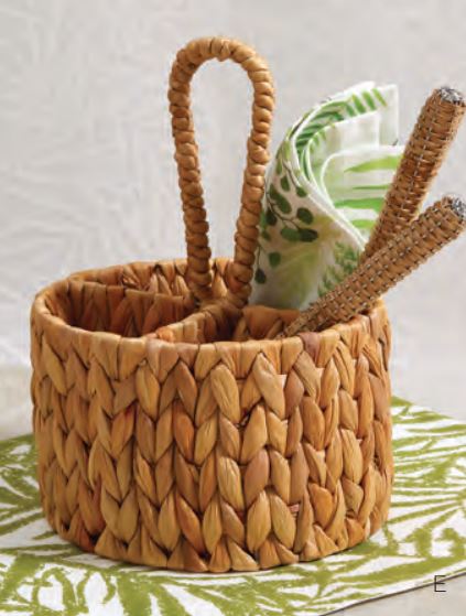 hyacinth basket with 4 sections and a loop handle set on a table and holding silverware and napkins.
