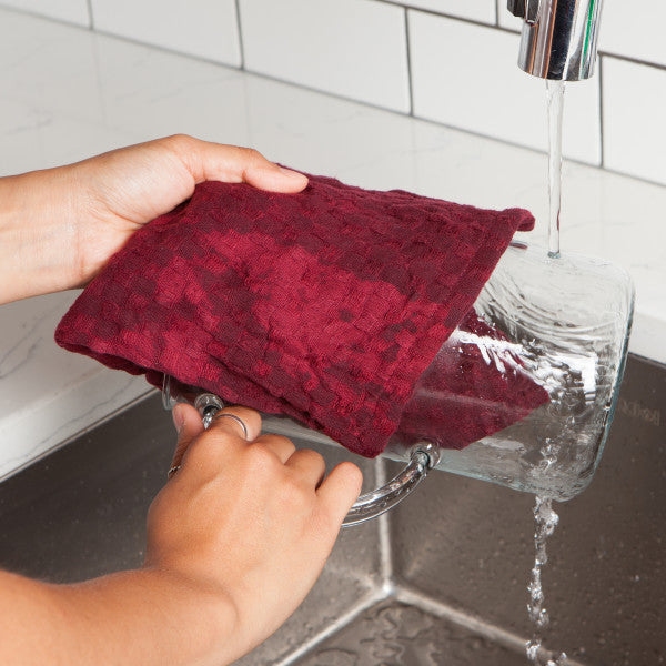 hands using dishcloth to wash dishes.