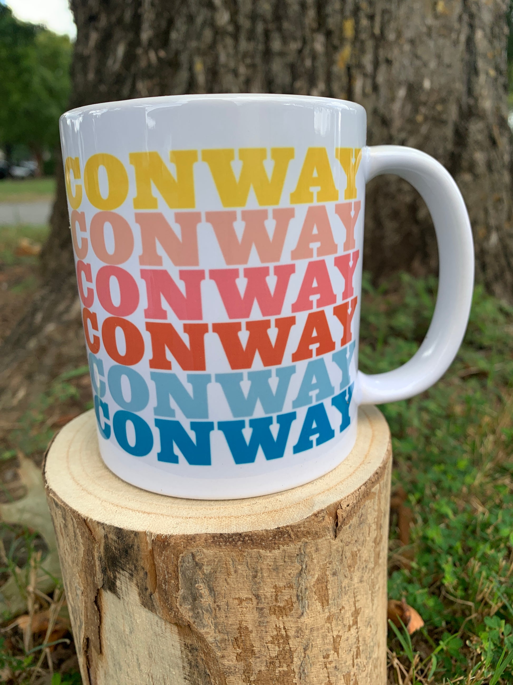 white ceramic mug with "conway" written six times in rainbow colors.