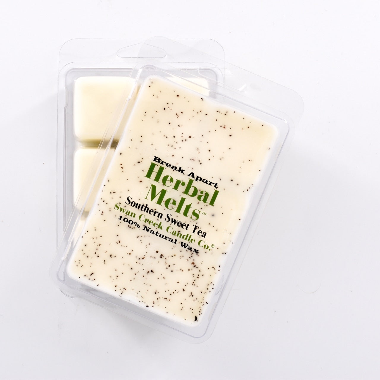 ivory colored wax with bits of black tea sprinkled on top in packaging with another package showing the bottom of the wax melts break apart design.