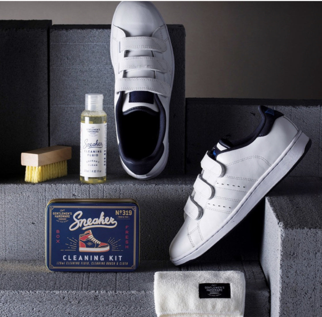 the sneaker cleaner kit displayed on stacked cinderblock next to tennis shoes