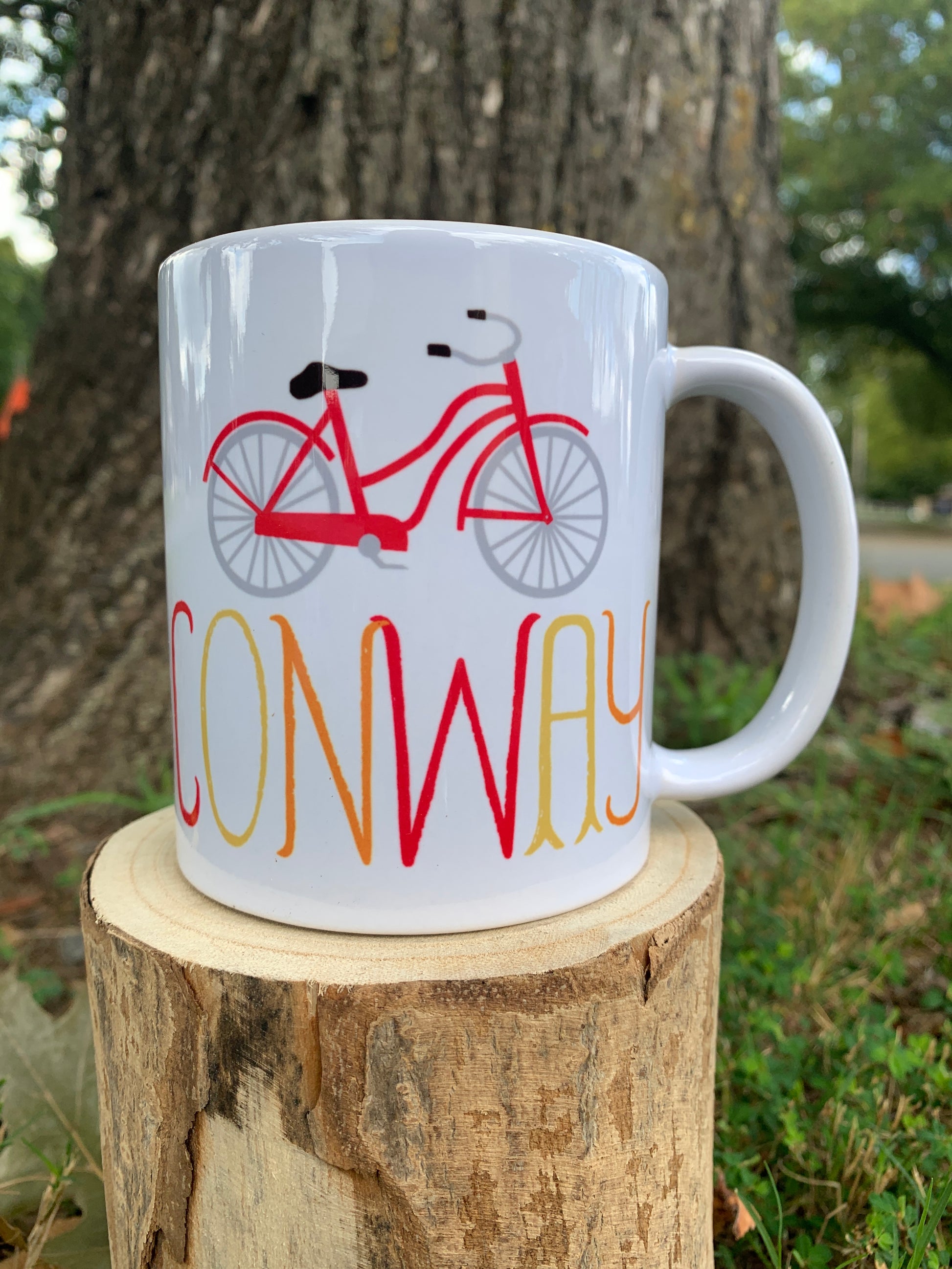 white ceramic mug with red bike graphic and "conway" text.