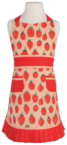 child's apron on mannequin, apron has an all-over strawberry pattern on a pink background with red waistband, bottom ruffle, and pockets.