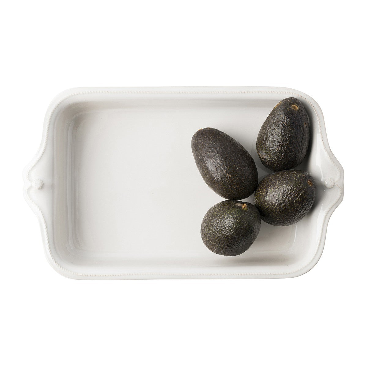top view of berry and thread rectangle baking dish with avocados on a white background