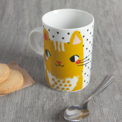 mug on table with spoon and cookies.