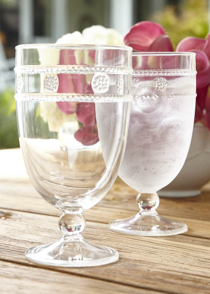 two isabella acrylic goblets displayed on a wood table with a floral arrangement
