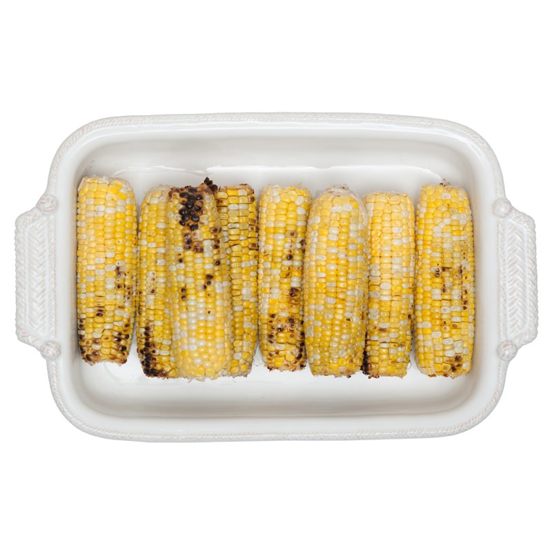 top view of the le panier rectangle baking dish filled with corn on a white background