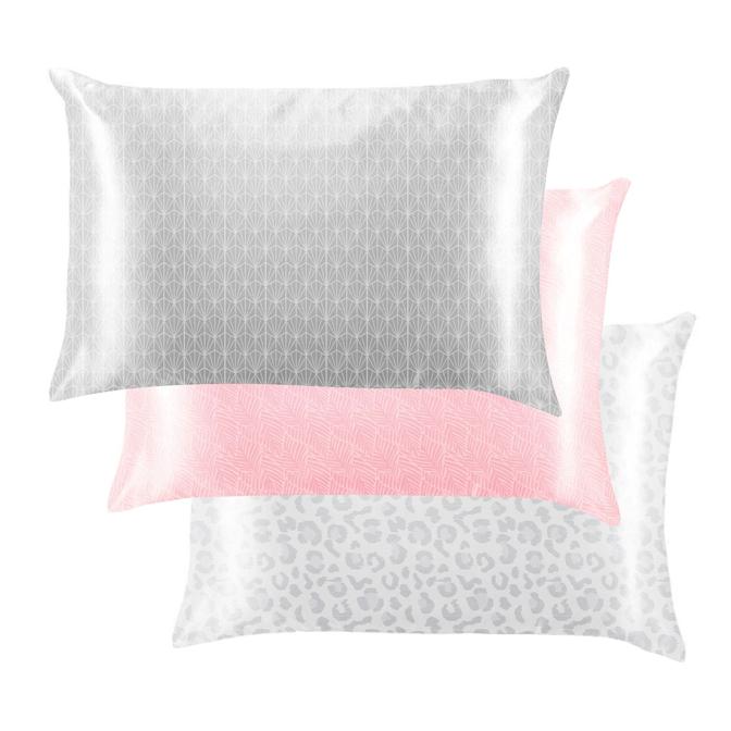 three different patterned satin pillow cases on a white background
