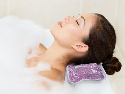 a woman taking a bath with her head resting on the stress less spa pillow against a white background