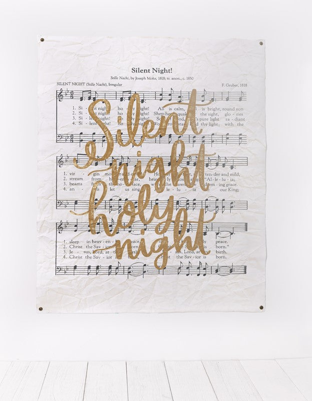 textured paper printed with silent night music and "silent night holy night" printed in gold script.