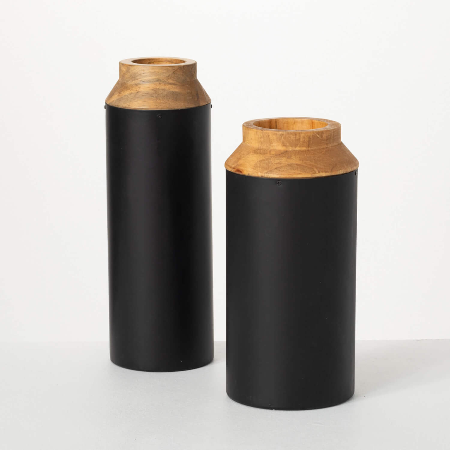 both sizes of black metal and wood vases against a light gray background
