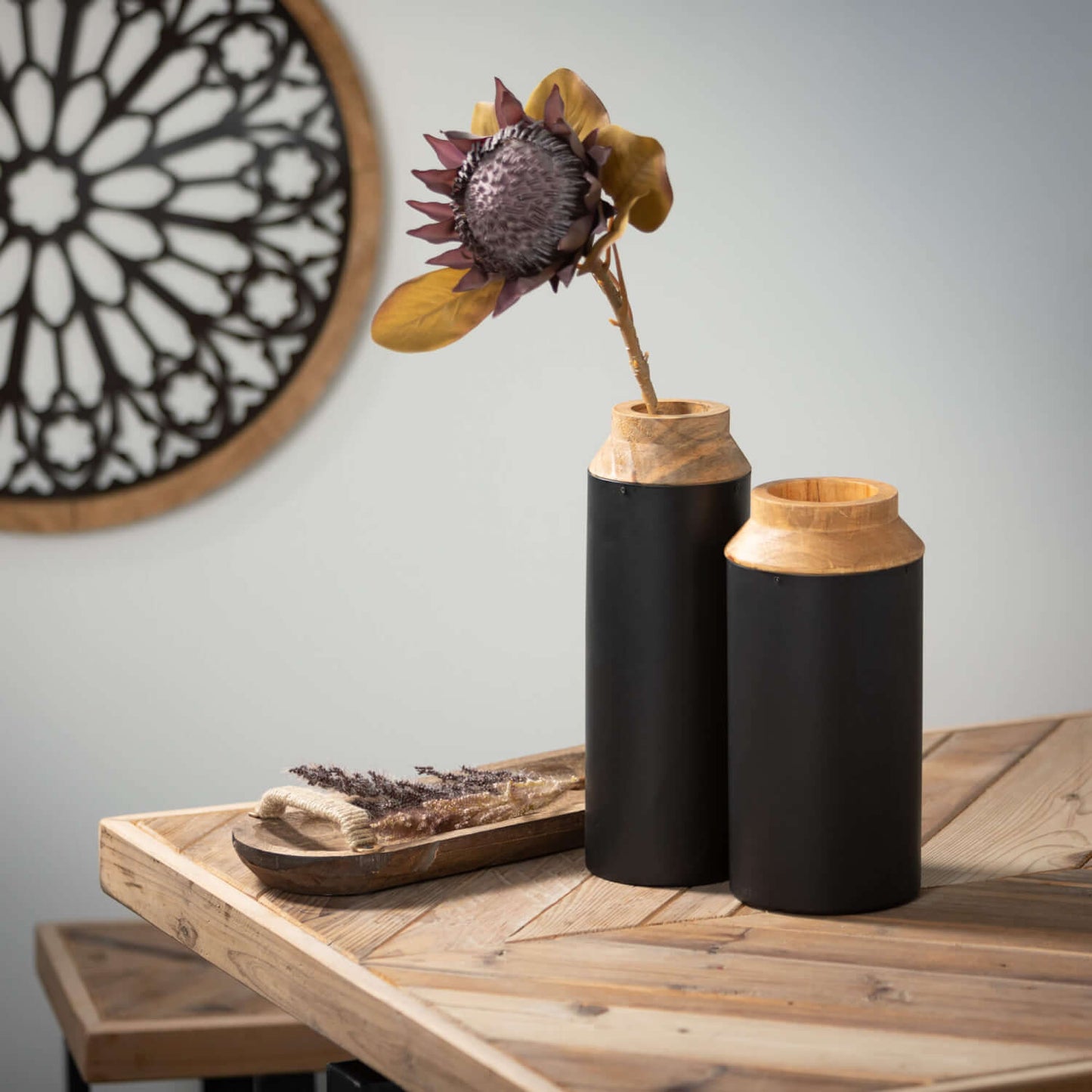 both sizes of metal and wood vases displayed on a rustic wood table with a large dried sunflower in the tallest one
