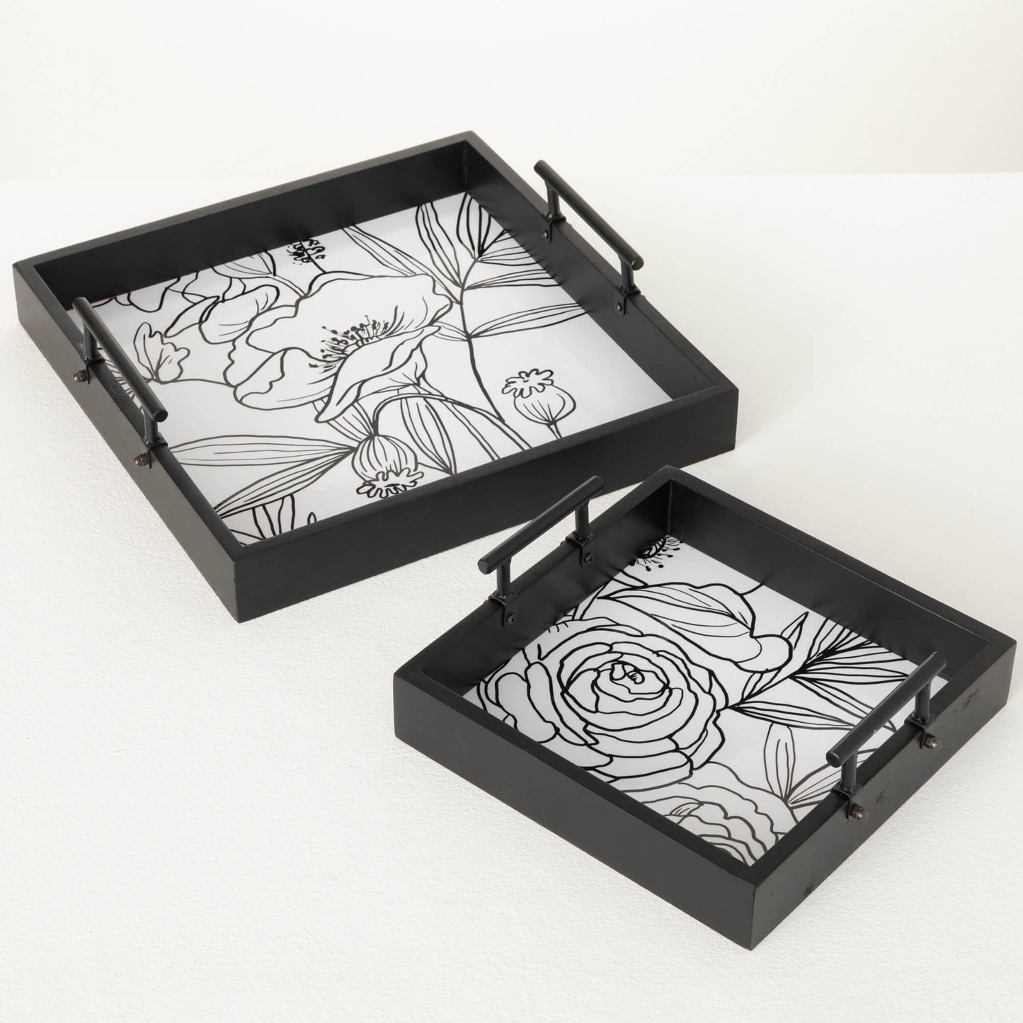 2 sizes of black wooden trays with white base in the interior with line drawings of a dahlia in small tray and poppies in the large tray.