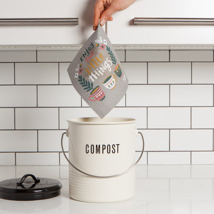 hand holding swedish dish cloth above compost pail.