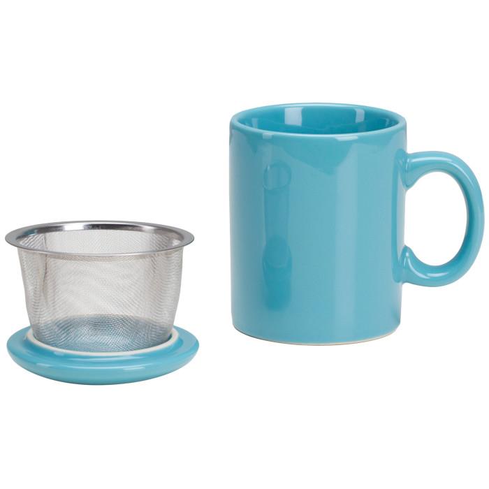 teal mug sitting next to tea strainer set on mug's teal lid.