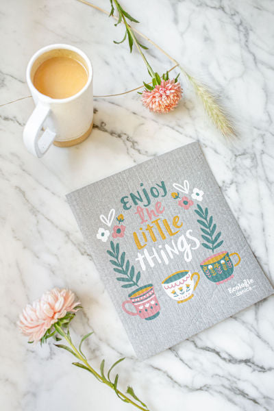 grey swedish dishcloth with "enjoy the little things" and floral graphics.