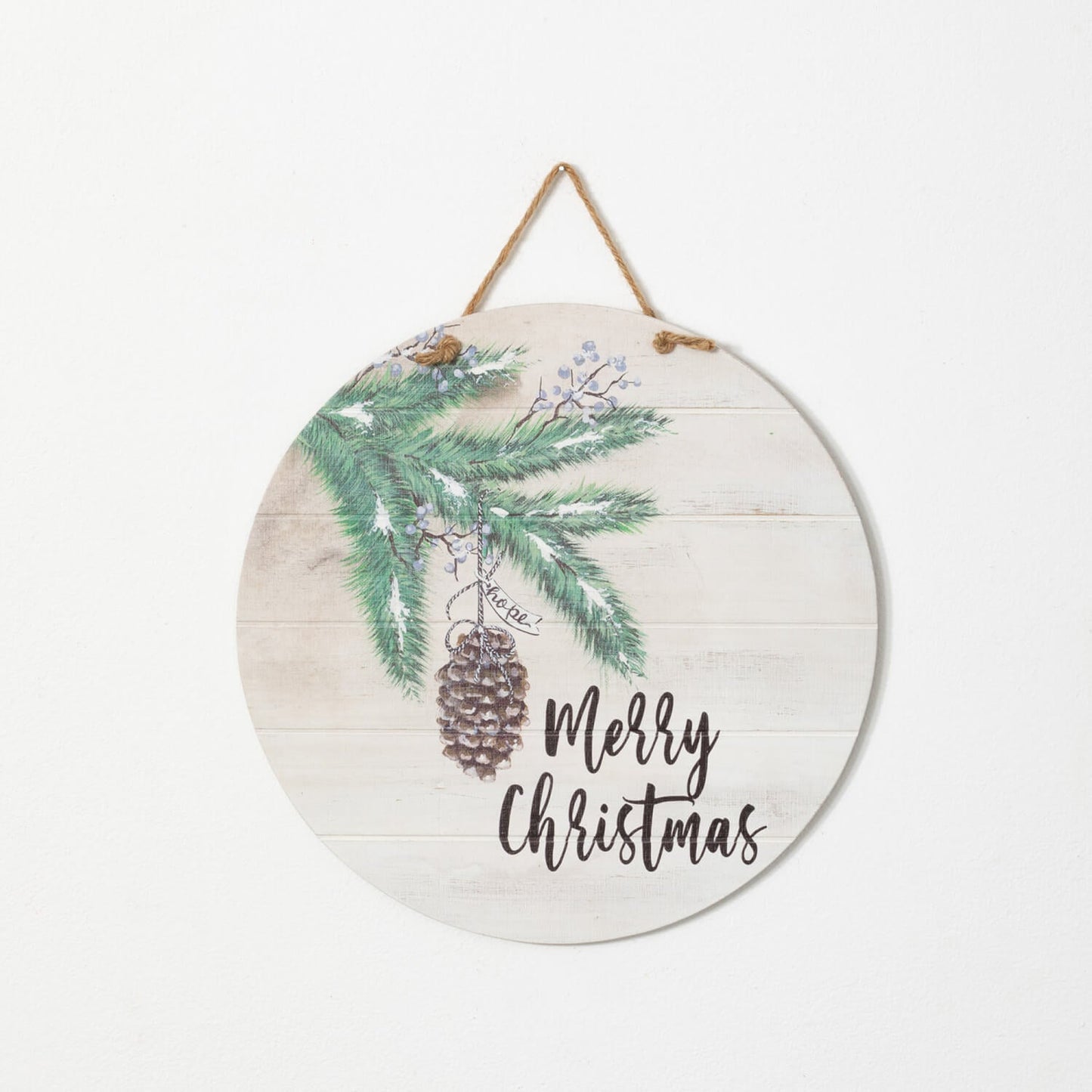 round wooden sign with evergreen art and "merry christmas" in black across the bottom.