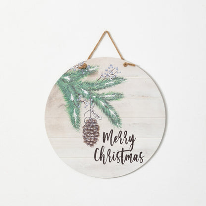 round wooden sign with evergreen art and "merry christmas" in black across the bottom.